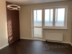 Ремонт двухкомнатной квартиры под ключ: комната с бронзовой 3D-панелью на стене, кольцевым светильником и окном с выходом на балкон
